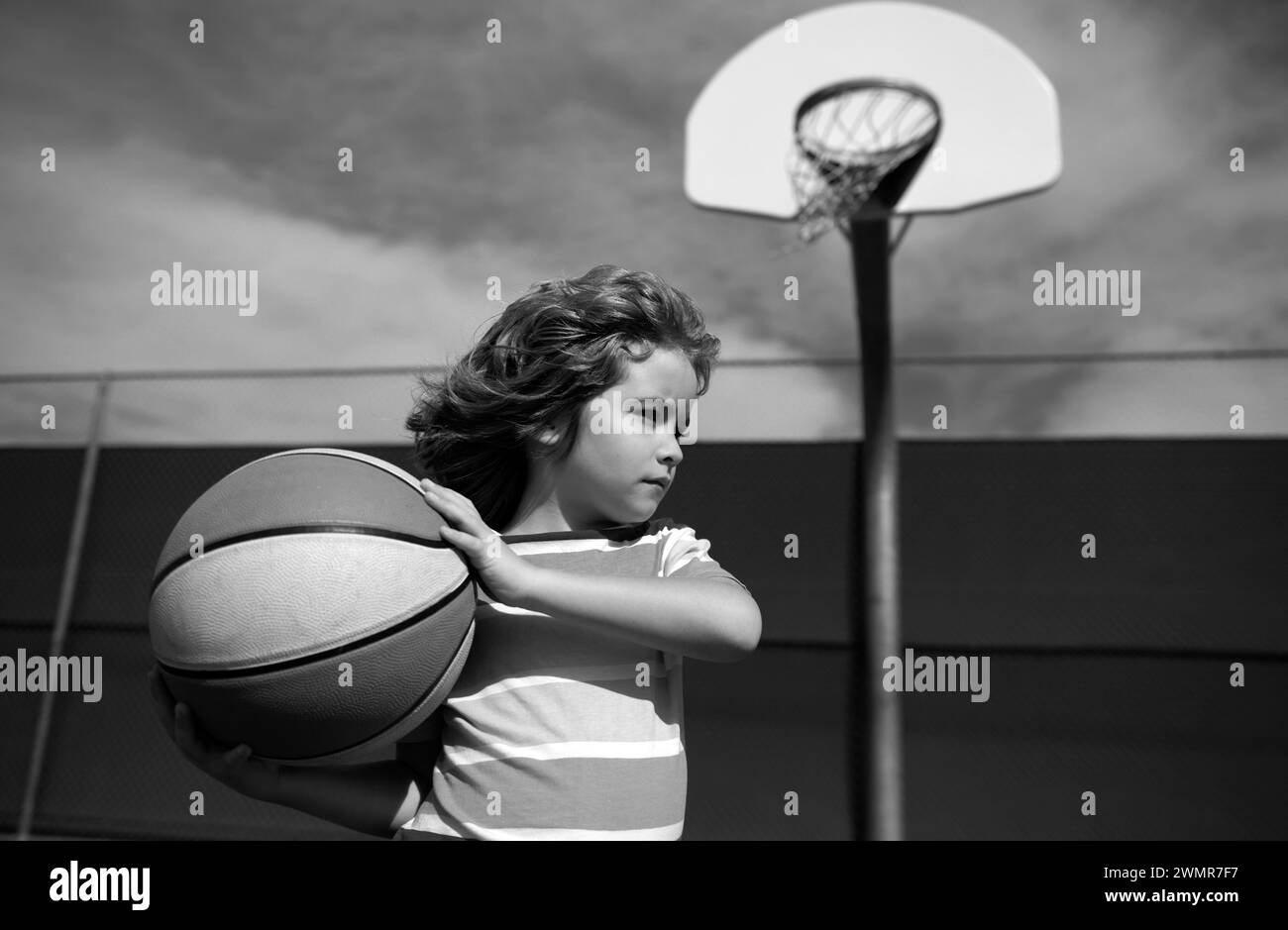 Cute child playing basketball. Basketball kids training game. Active