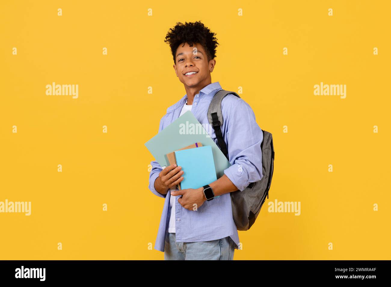 Smiling black student guy with backpack holding books Stock Photo