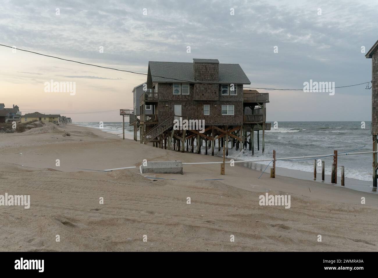 Houses crumble into the sea in Outer Banks due to some of the most rapid rates of coastal erosion and sea level rise on the East Coast, USA. Stock Photo