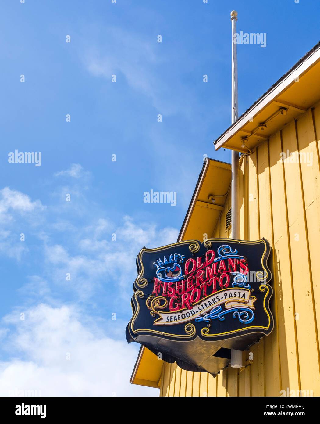 Neon sign and yellow building off the famous Old Fisherman's Grotto seafood restaurant at the landmark fisherman's wharf in Monterey, California Stock Photo