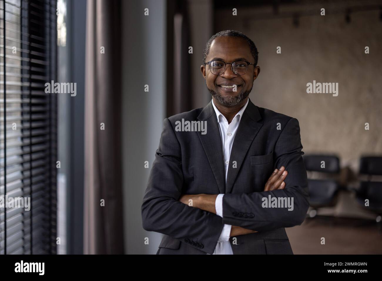 A professional African American man in a suit stands confidently in an ...