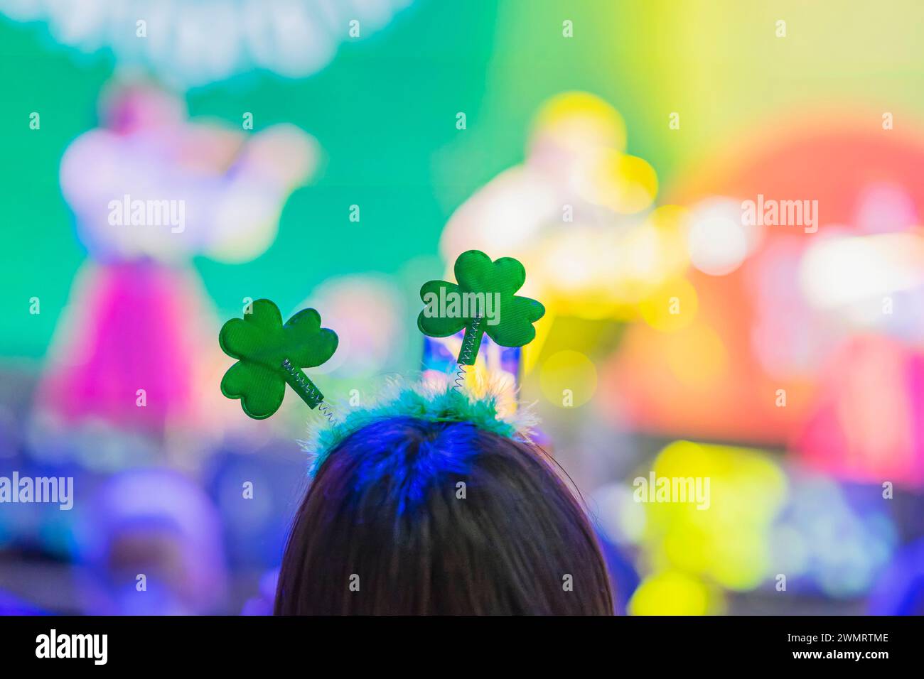 Back view of girl with Clover head decoration on head close-up. Saint Patrick's Day celebration in club Stock Photo