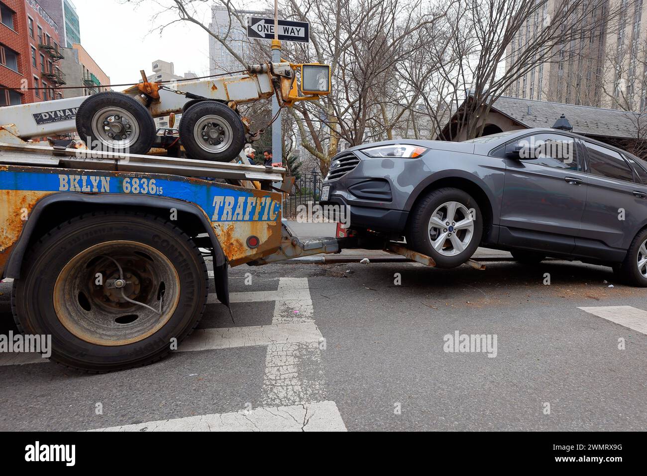 A NYPD Traffic wheel lift tow truck towing a car in Manhattan, New York City Stock Photo