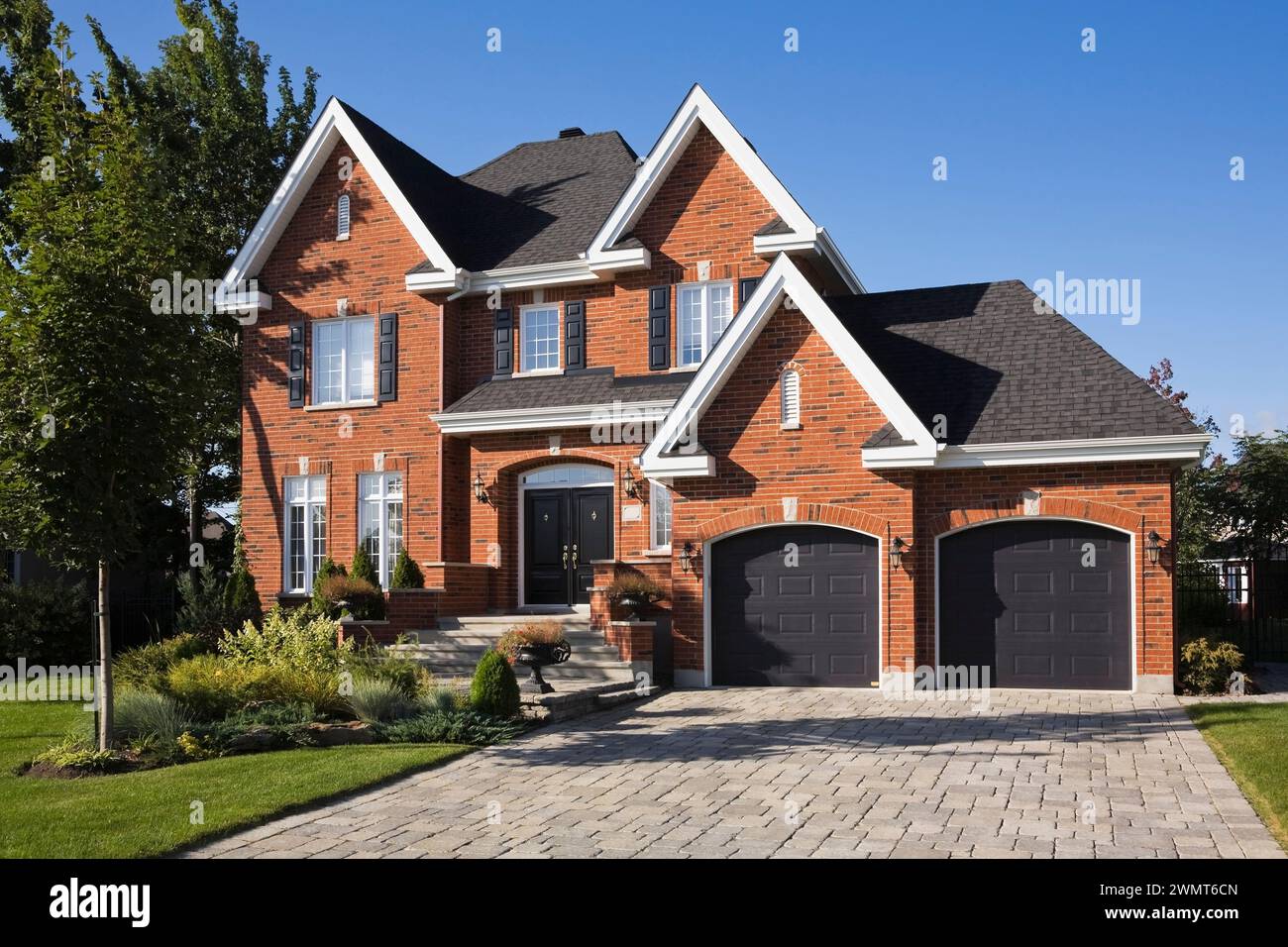 Upscale two story red and black brick home with two car garage, paving ...