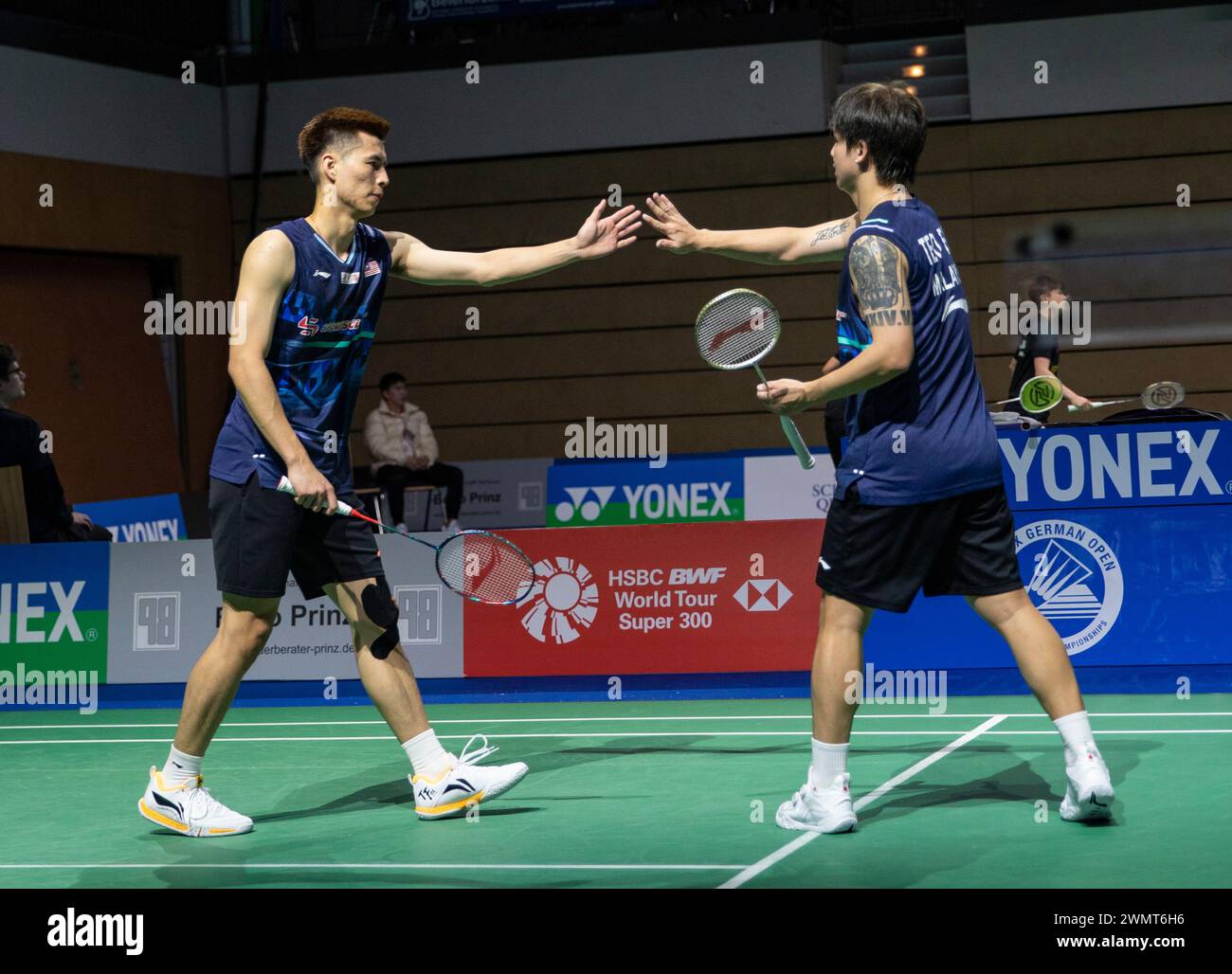 Muelheim, Germany. 27th Feb, 2024. Ong Yew Sin/Teo Ee Yi (R) of Malaysia clap hands during the men's doubles first round match between Ong Yew Sin/Teo Ee Yi of Malaysia and Eloi Adam/Leo Rossi of France at Yonex German Open 2024 badminton tournament in Muelheim, Germany, Feb. 27, 2024. Credit: Zhang Fan/Xinhua/Alamy Live News Stock Photo