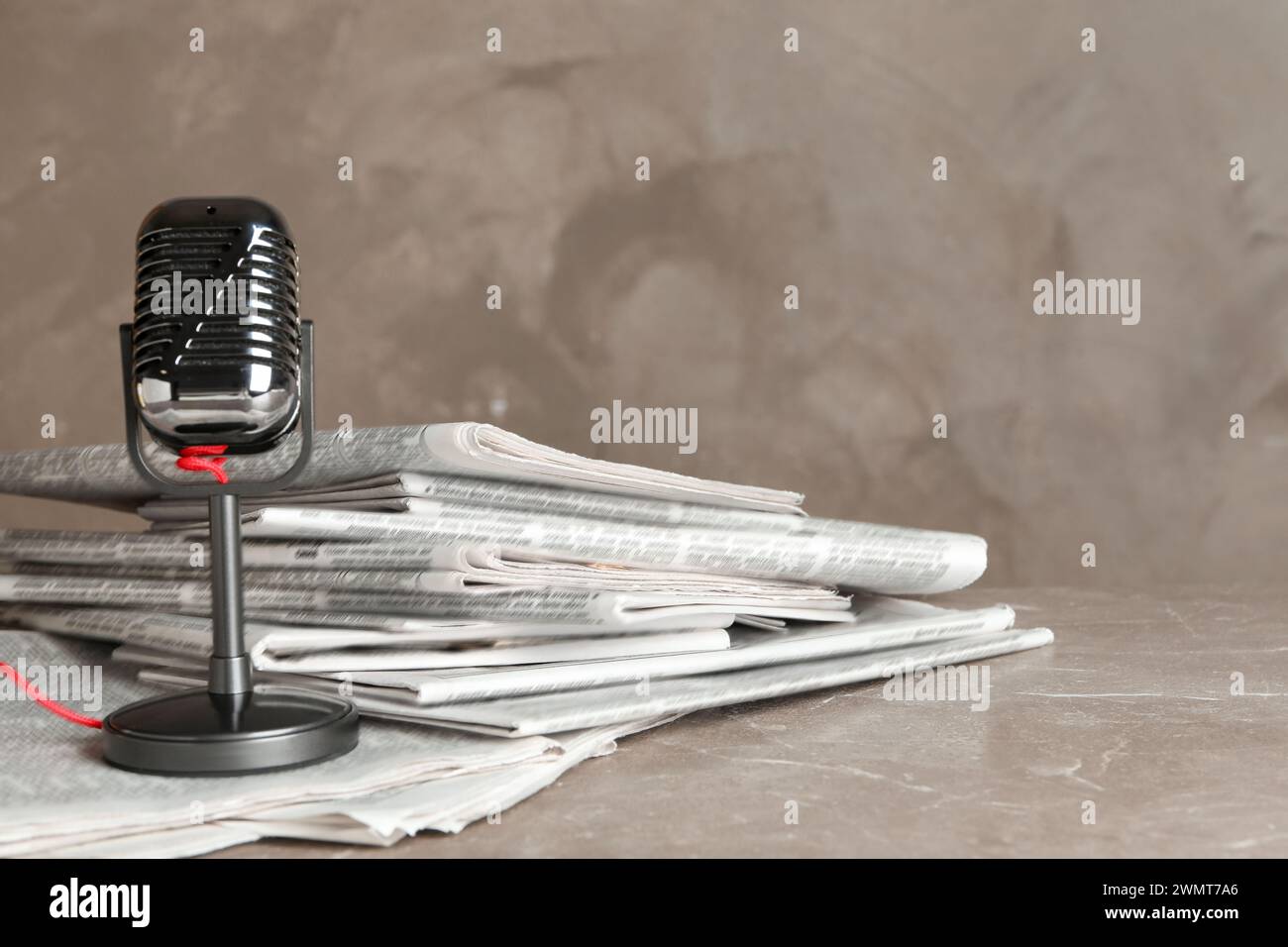 Newspapers and vintage microphone on marble table. Journalist's work Stock Photo