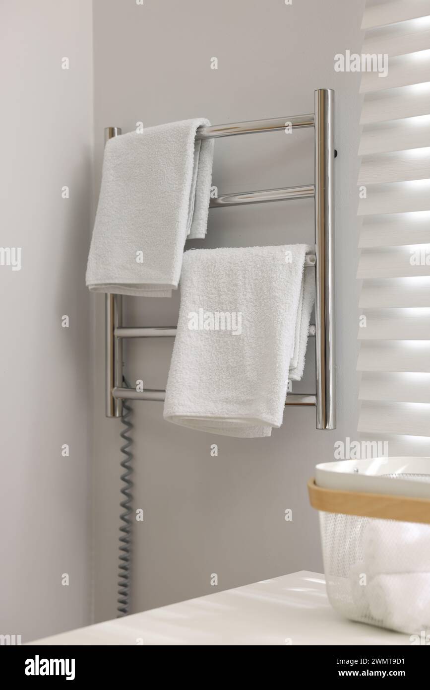 Heated towel rail with towels in bathroom Stock Photo - Alamy