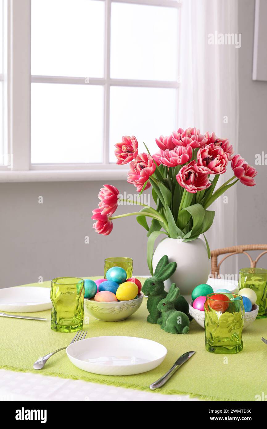 Beautiful table serving with red tulips for Easter celebration Stock Photo