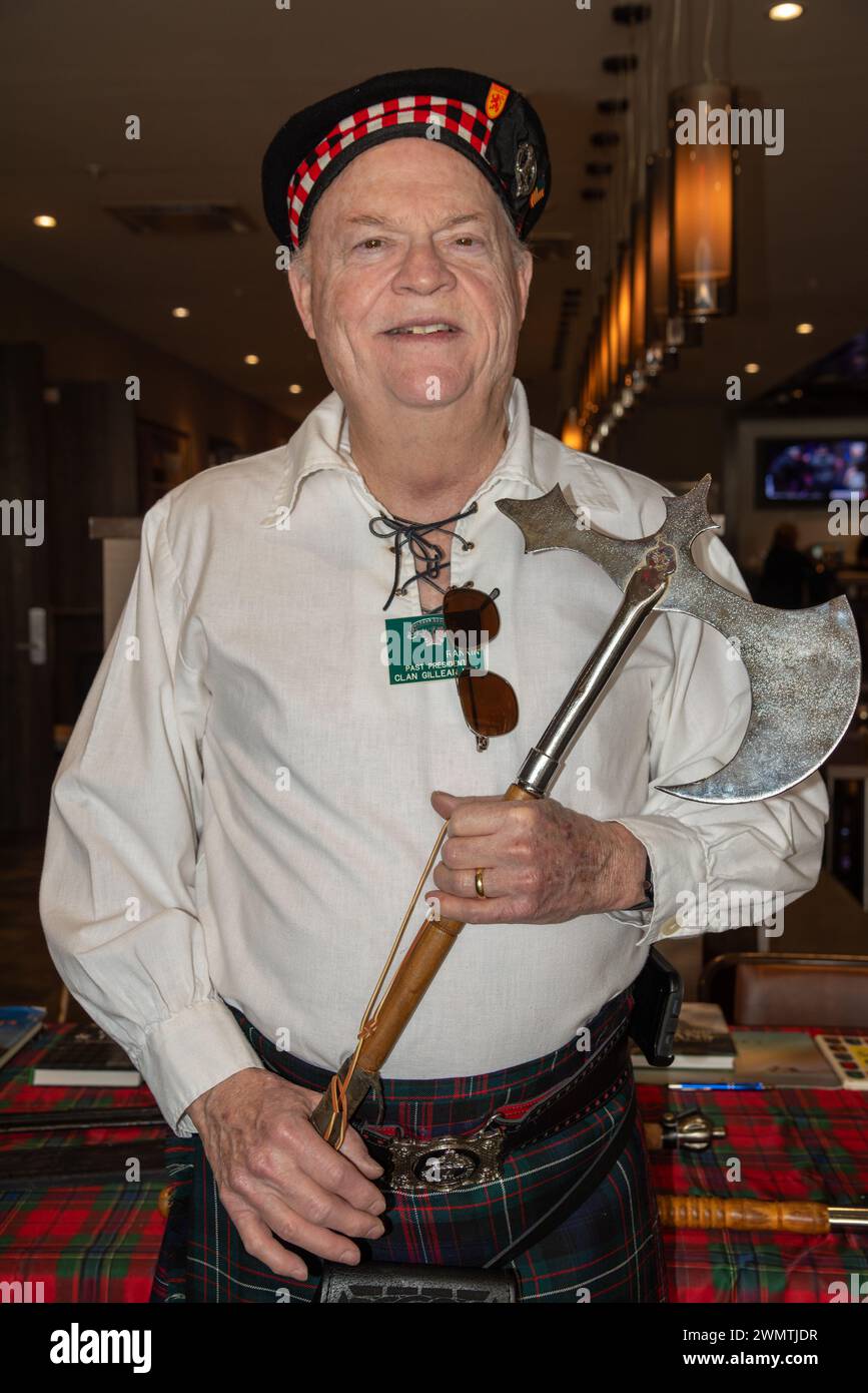 A man in a cap and tartan kilt holds a battle axe at the South Texas Irish Fest 2024, McAllen, Hidalgo County, Texas, USA. Stock Photo