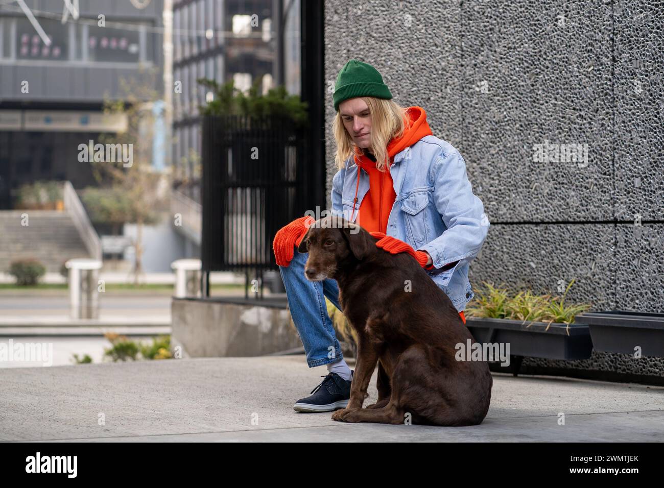 Stylish guy pet owner walking with dog relaxes outside breathing air stroking docile obedient pet. Stock Photo