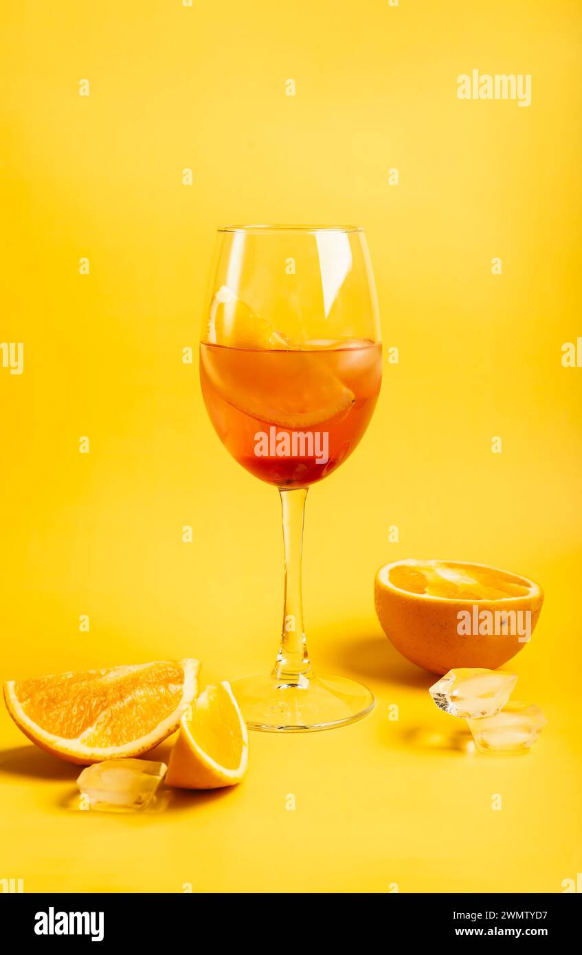 Cocktail Aperol spritz with oranges and ice on bright yellow background Stock Photo