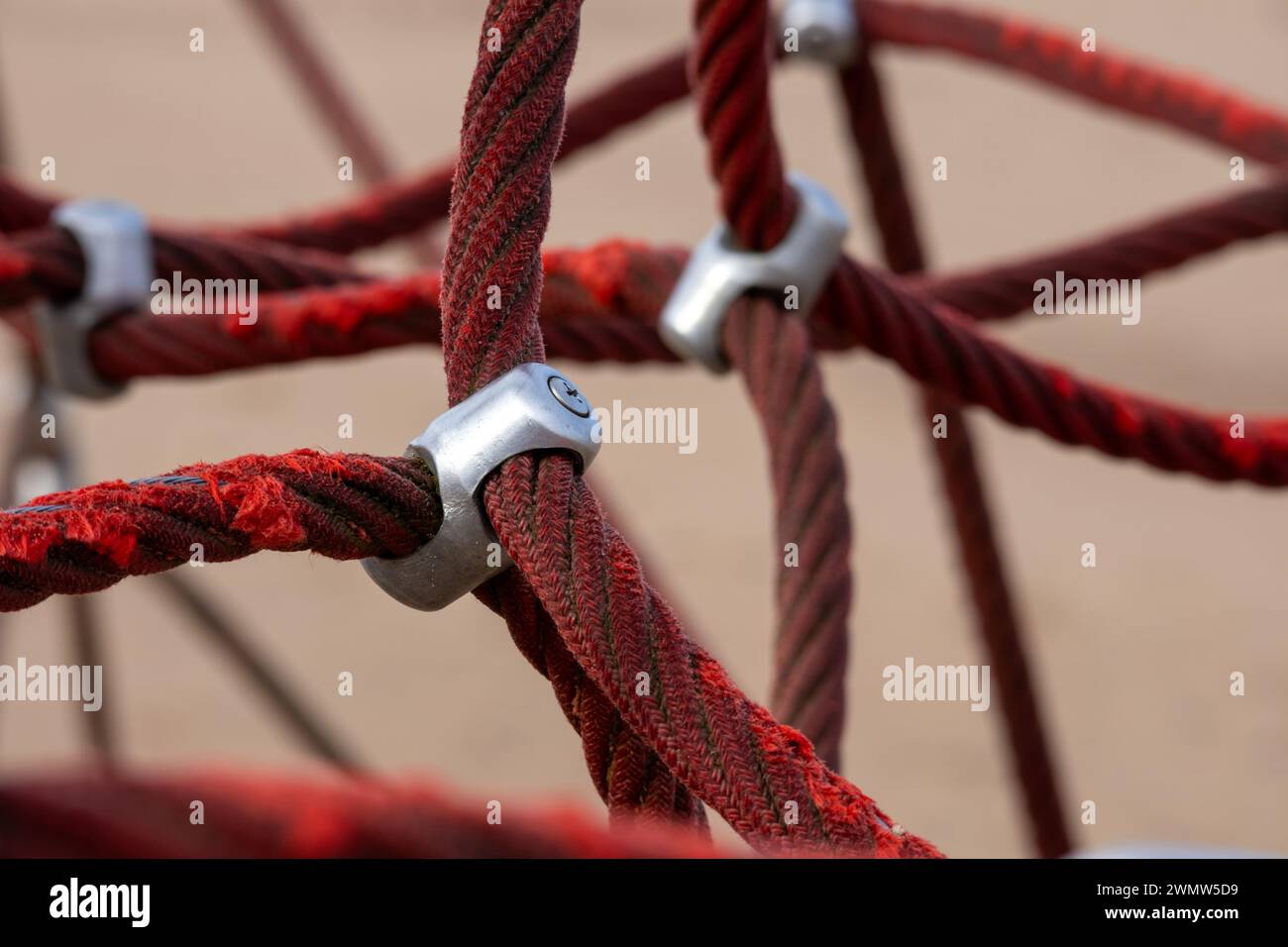 Red rope sections fastened with a metal clamp and a brown sand ...