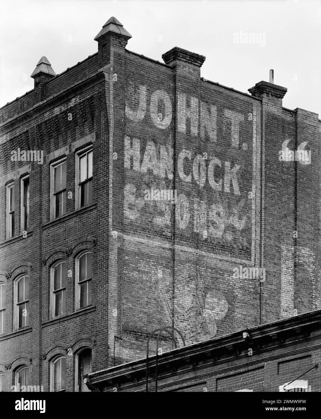 Upper level detail of  Southeast side, showing parapet, chimneys and party wall sign. View to North - Commercial & industrial Buildings,  Bishop's Block, 90 Main Street, Dubuque Stock Photo