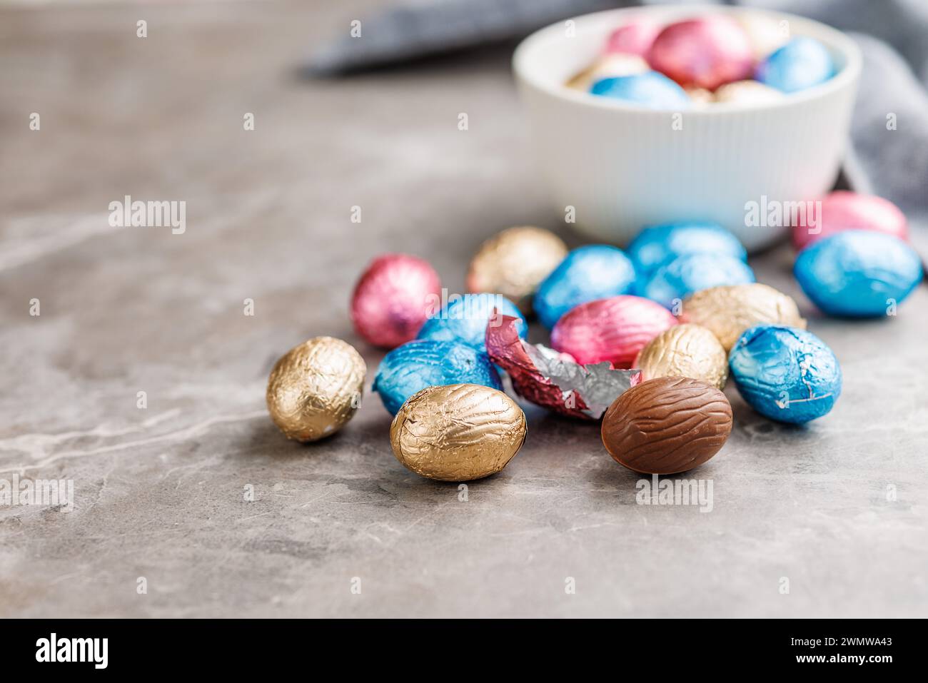 Easter chocolate eggs wrapped in aluminium foil on the kitchen table. Stock Photo