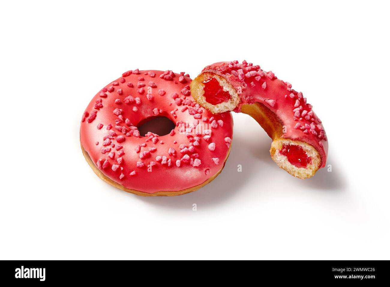 Vibrant red glazed soft donuts with sweet and sour berry jelly filling sprinkled with sugared berry crumbs, isolated on white background. Handcrafted Stock Photo