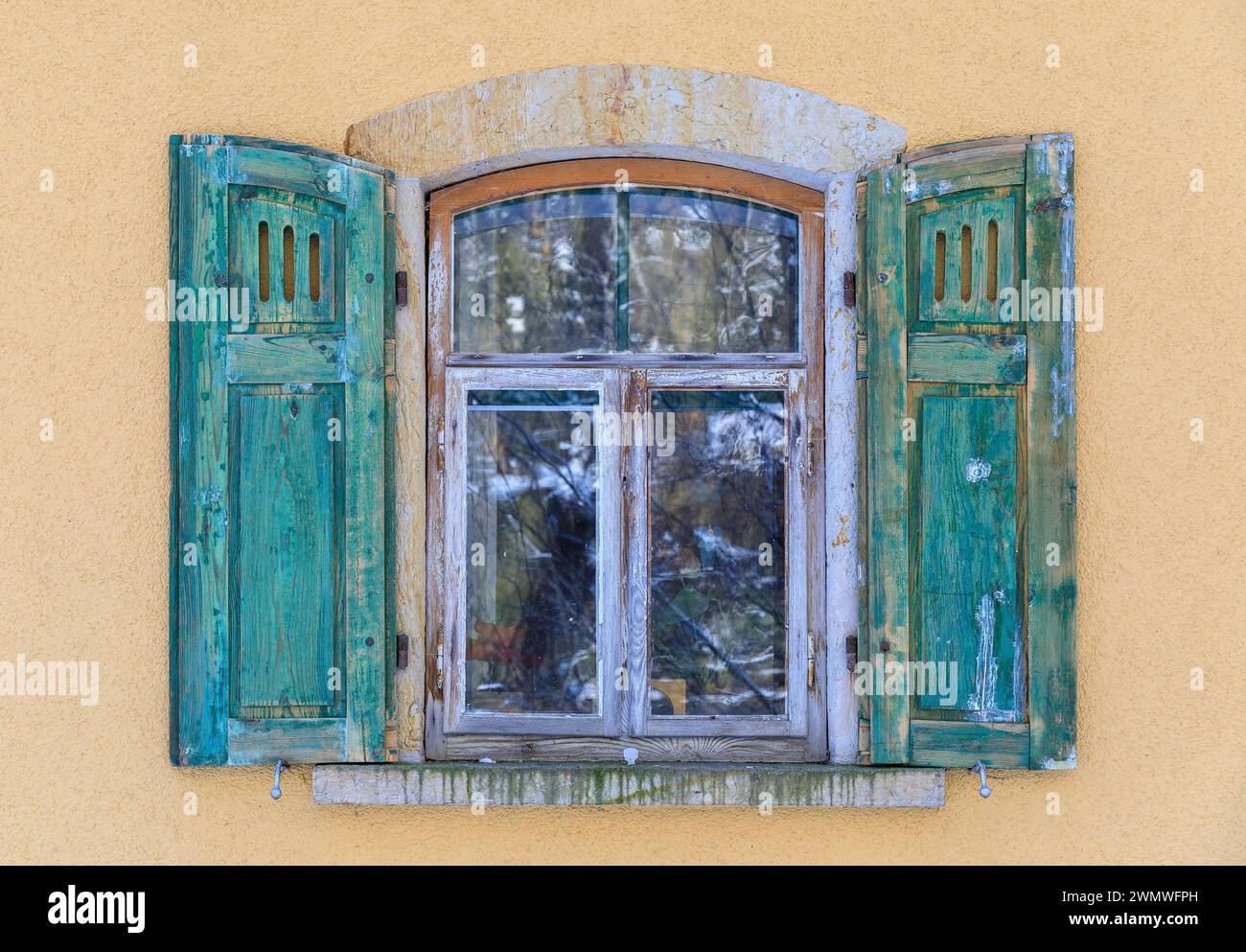 Holzfenster mit grünen Fensterläden und gelber Hauswand an einem Wohnhaus im Wesenitztal bei Elbersdorf, Dürröhrsdorf-Dittersbach, Sachsen, Deutschlan Stock Photo