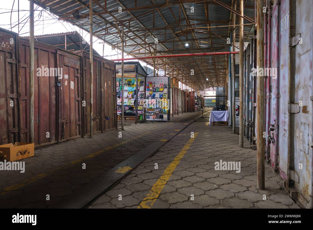 A view of a mostly empty area of the market, shipping containers shut, corridor quiet. At the Barakholka shipping container local market in Almaty, Ka Stock Photo