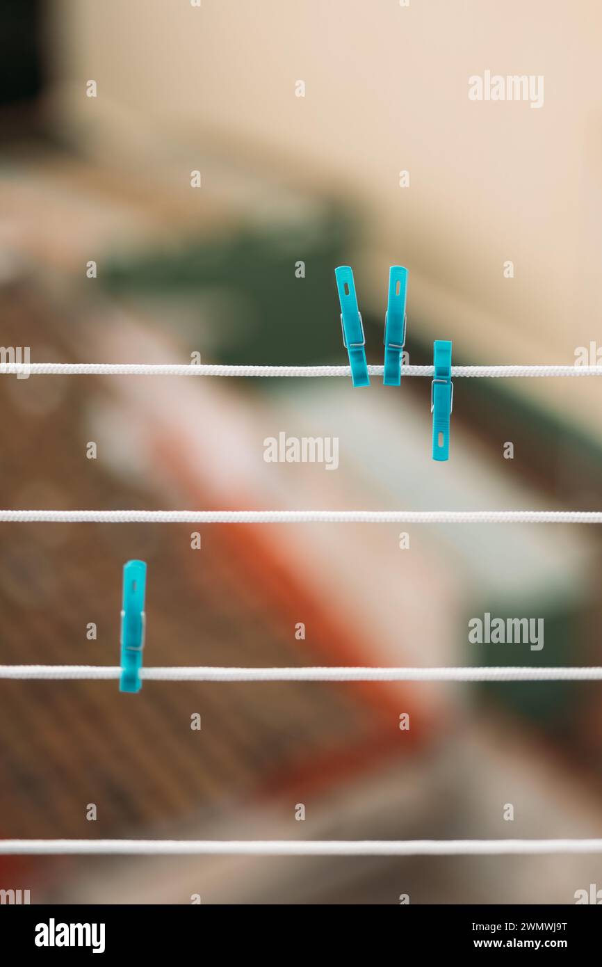 Blue Clothespins on white clothesline with blurred background Stock Photo