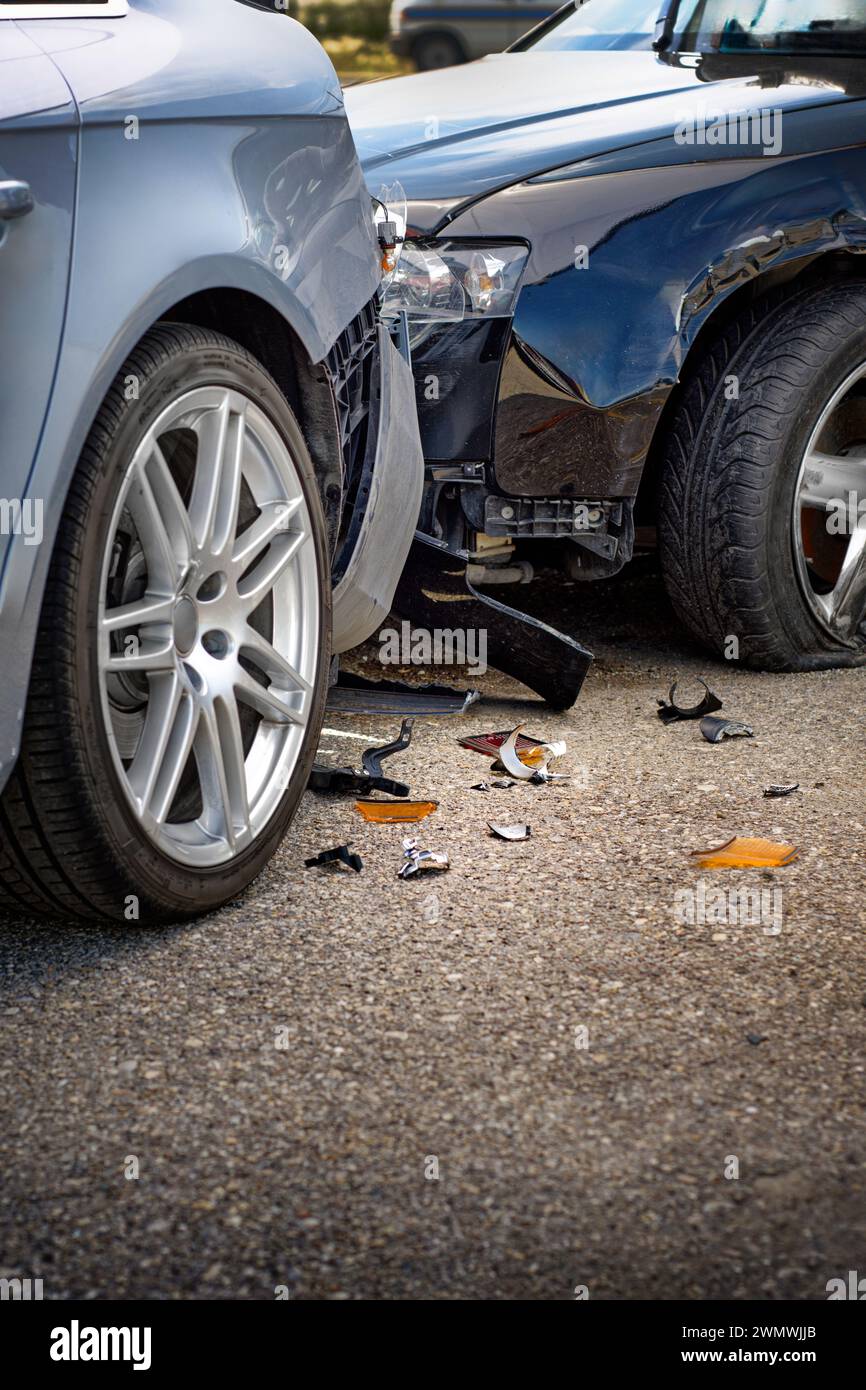 The two luxury cars collide in an accident, scattered broken pieces on the ground Stock Photo