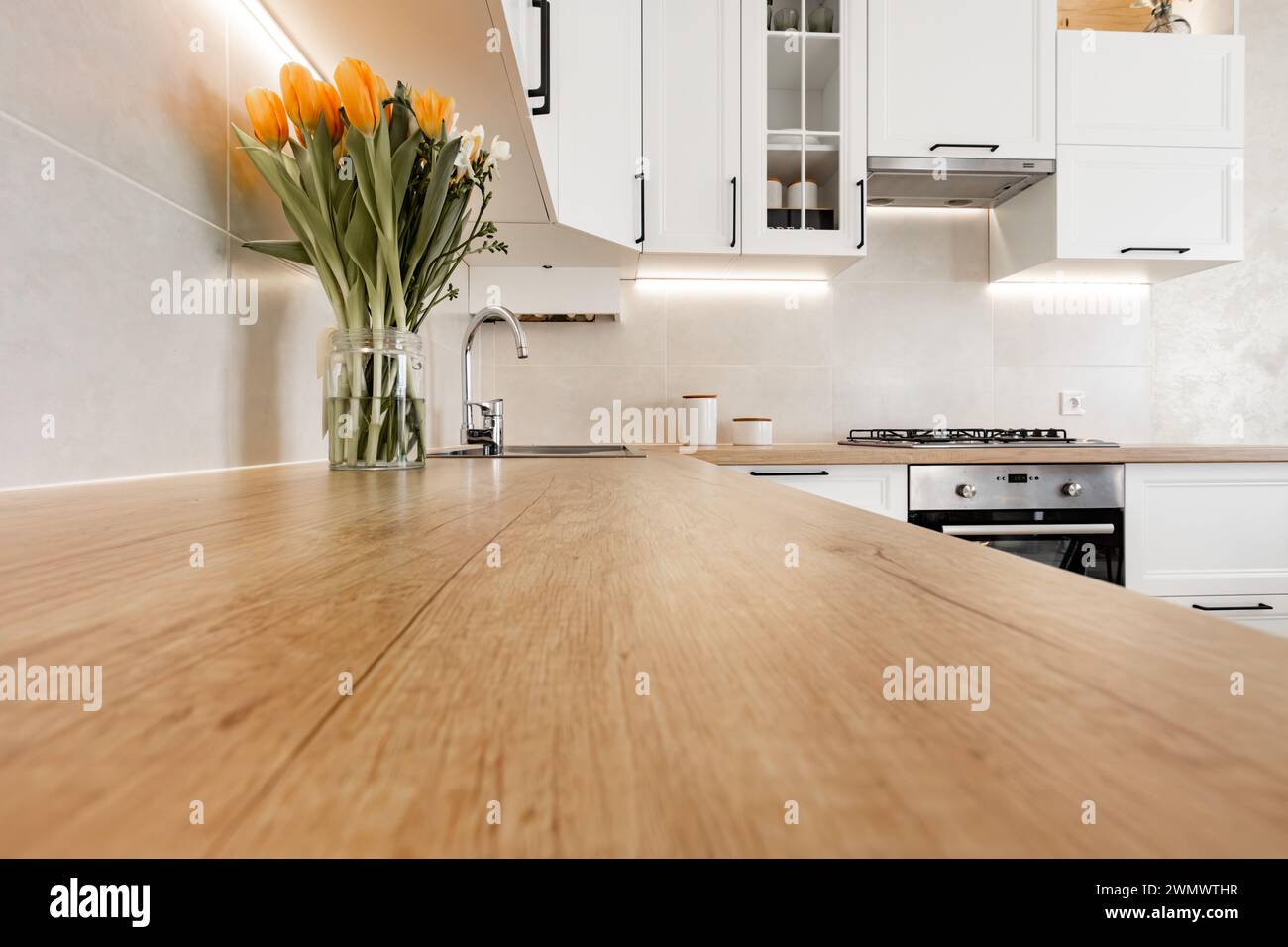 a modern white kitchen interior with wooden worktop Stock Photo - Alamy