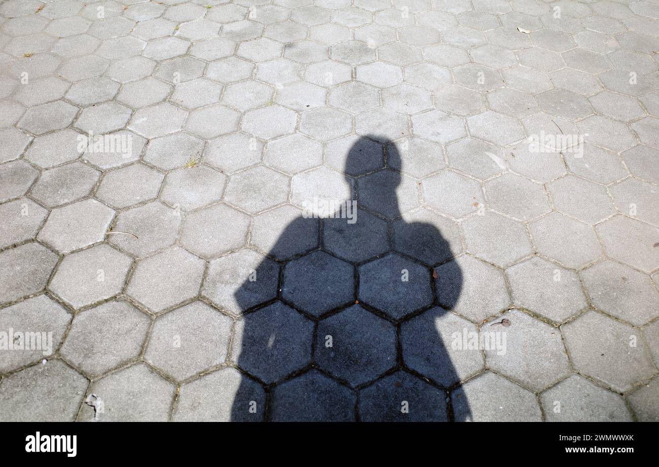 A shadow of person standing on the block floor, in the morning. Stock Photo