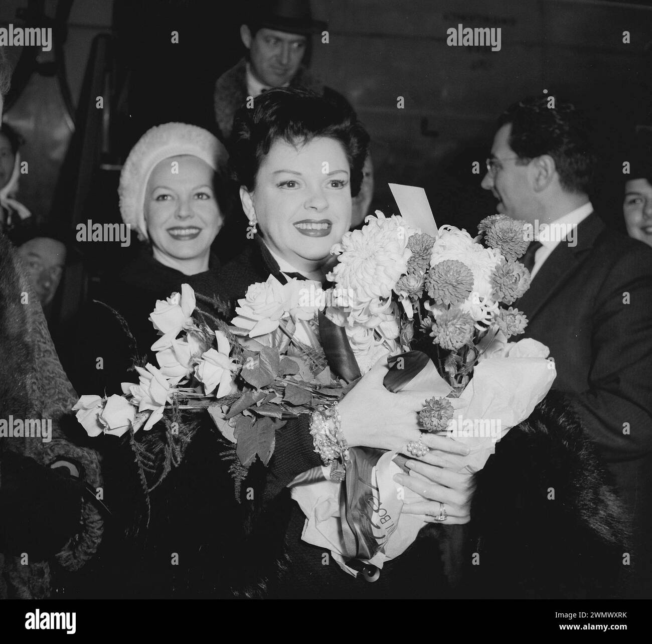 December 9, 1960. Amsterdam, Netherlands. Judy Garland with large bouquet of flowers as she arrives at Schiphol airport Stock Photo