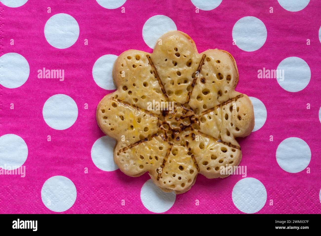 Blooming Lovely Crumpet light fluffy flower shaped crumpet from M&S on pink polka dots napkin serviette Stock Photo