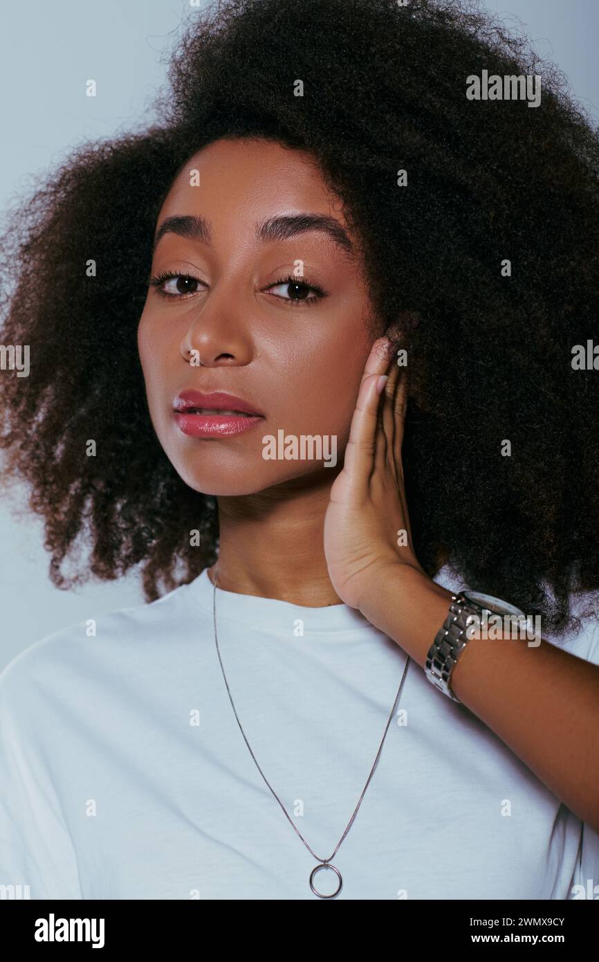 beautiful african american woman in chic attire with curly hair looking at camera, fashion concept Stock Photo