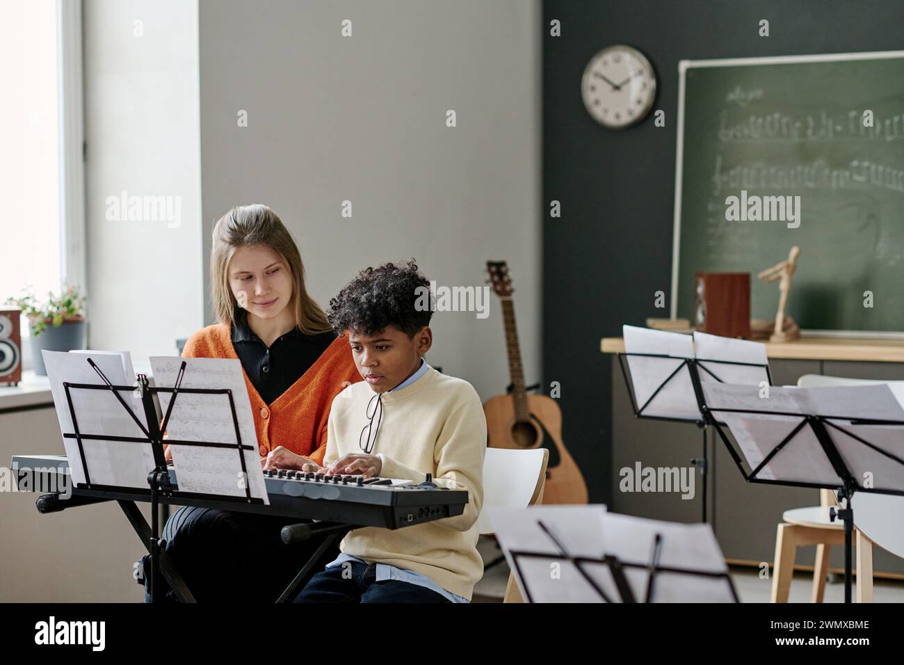 African American boy playing synthesizer at music lesson in classroom