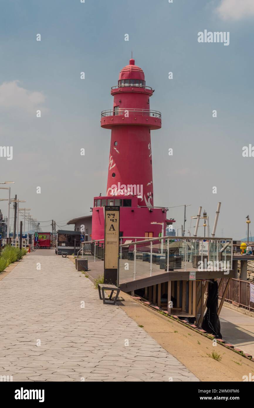 Oido red lighthouse on pier beside main street beside pedestrian walkway Stock Photo