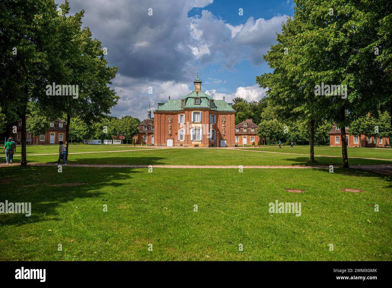 Red castle surrounded by lawns and a cloudy blue sky, Clemenswerth Castle, Soegel, Lower Saxony Stock Photo