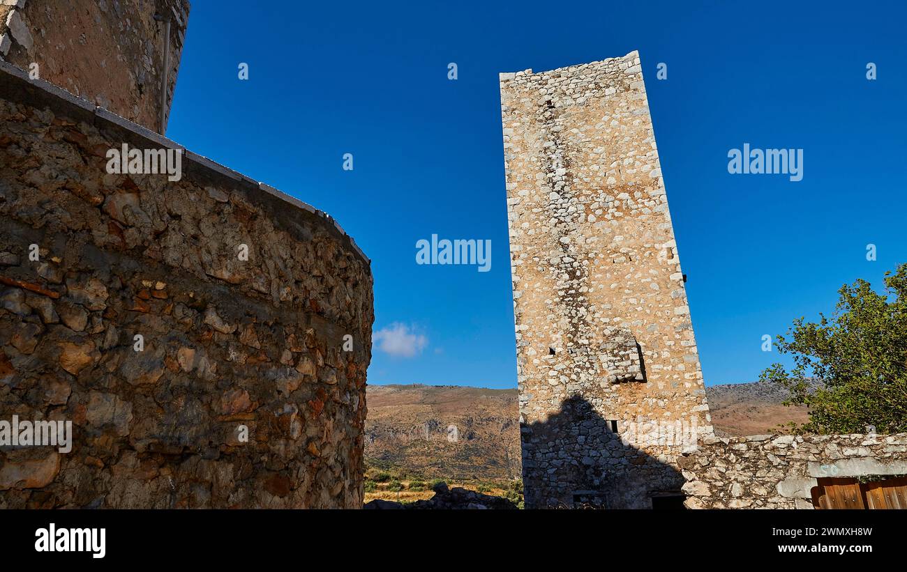 Towering historic stone tower against a deep blue sky, Flomochori, residential tower village, Mani peninsula, Peloponnese, Greece Stock Photo
