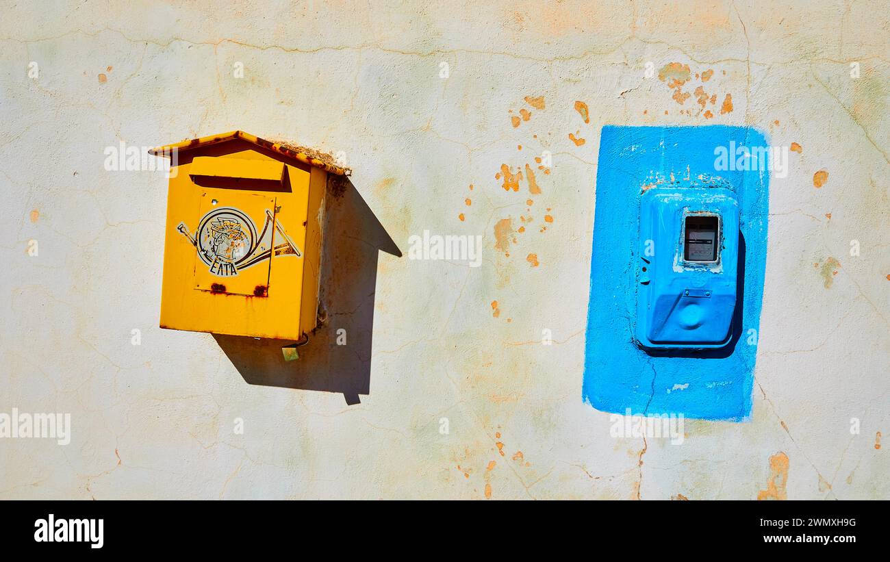 Yellow post box, Blazer electricity meter, house wall, Flomochori, residential tower village, Mani peninsula, Peloponnese, Greece Stock Photo