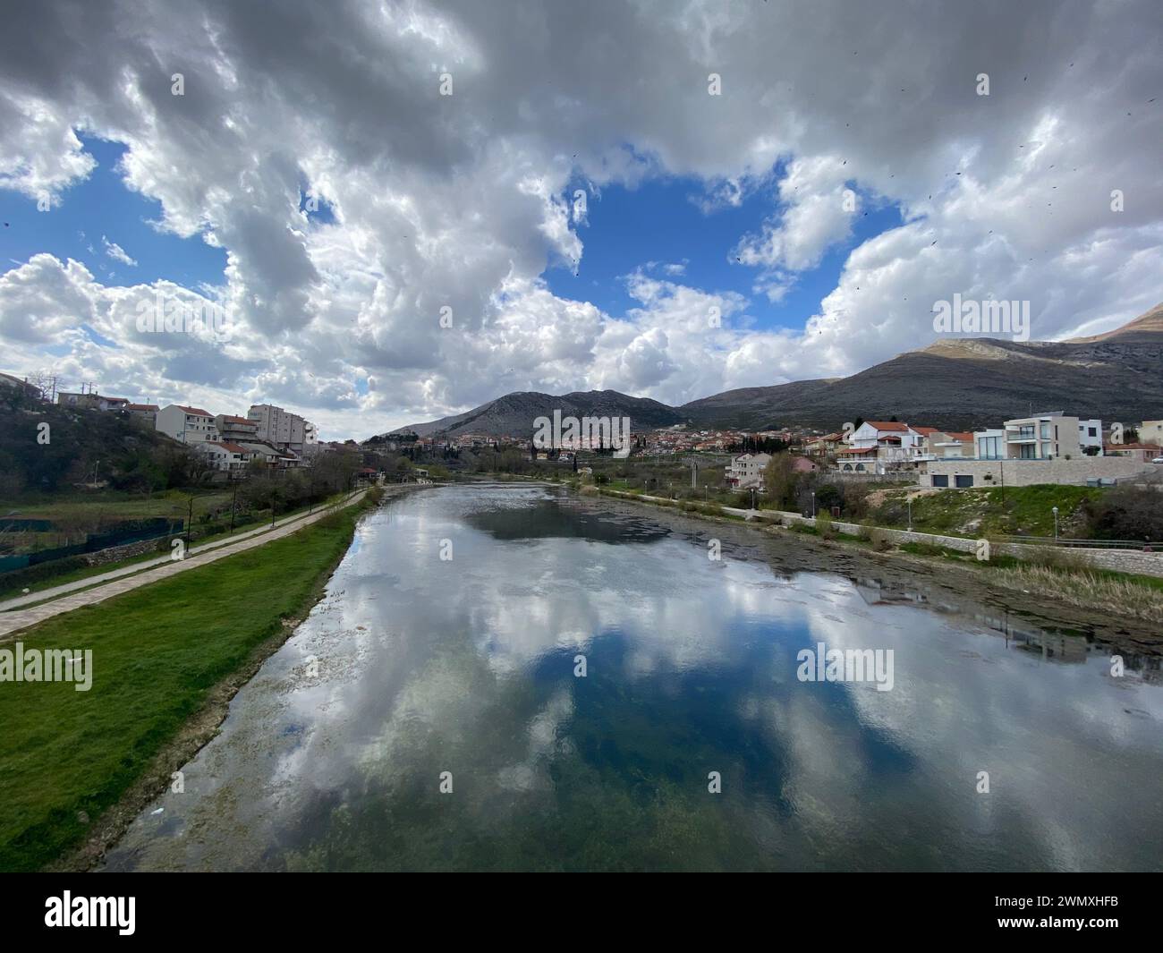 Riverside Illusions: The Sky's Choreography Mirrored in the Water Stock Photo