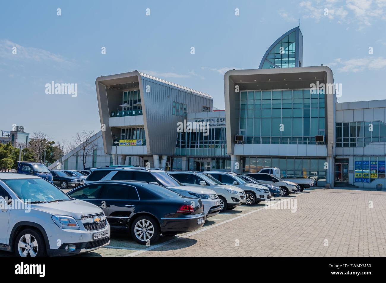 Rows of cars parked in front of Jeongok Marina Clubhouse on sunny morning in Pyeongtaek, South Korea Stock Photo