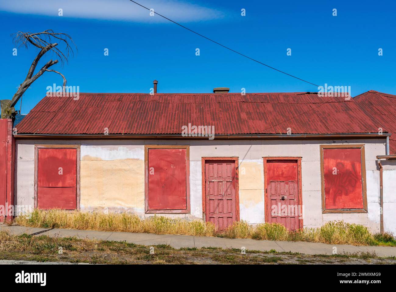 Boarded up house with red roof and red doors, city of Punta Arenas, Patagonia, Chile Stock Photo