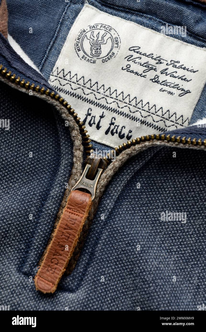Close up of Fat Face clothing brand label and zip on blue cotton