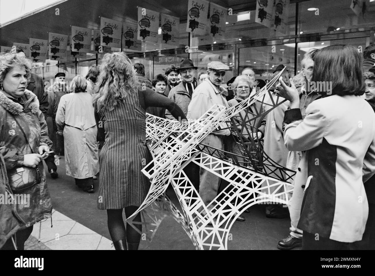 Employees carry a model of the Eiffel Tower across the pavement at the opening of the French