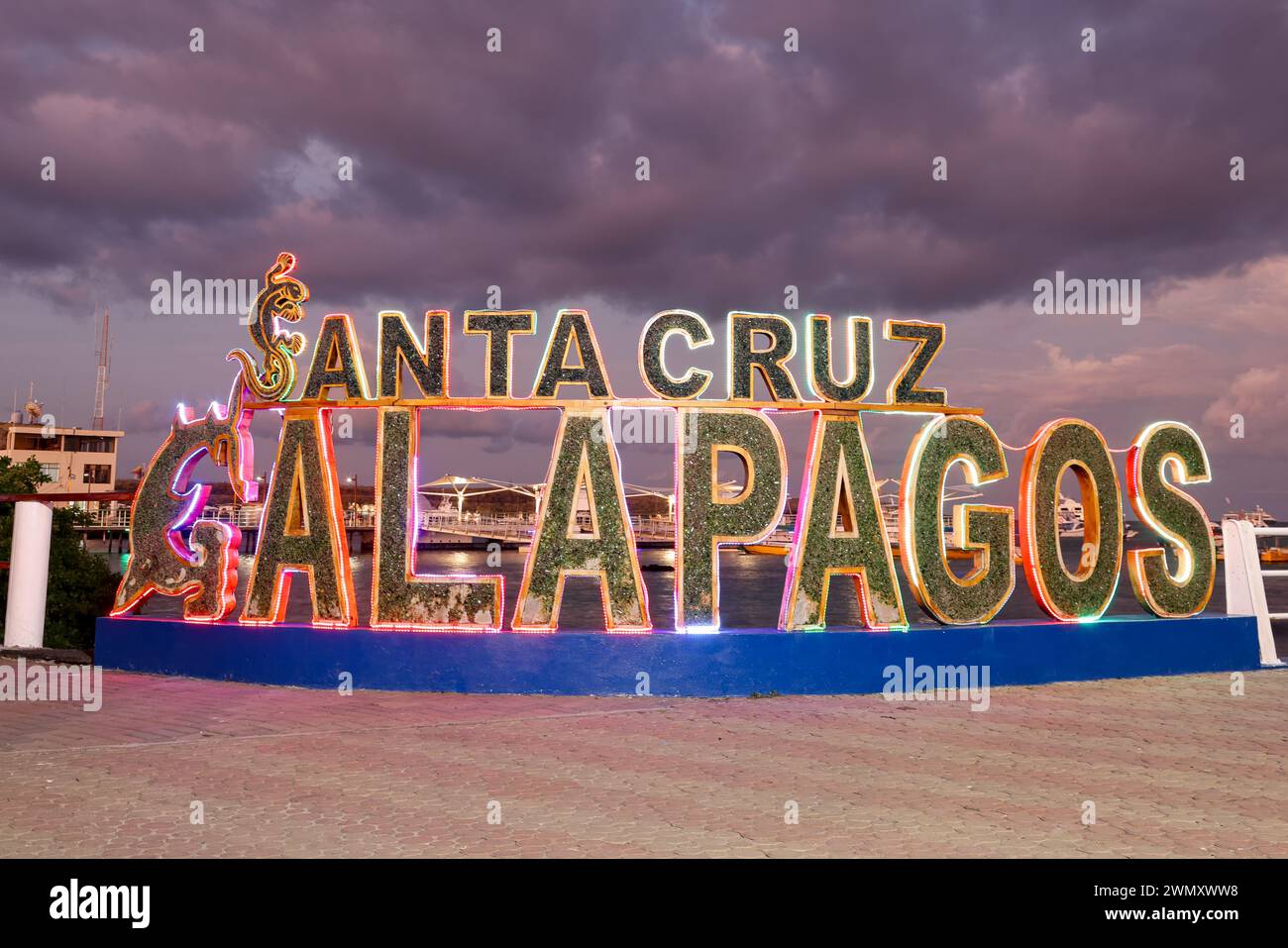 Santa Cruz Galapagos -Text Sign at the Puerto Ayora harbor during sunset withled lights on the galapagos island, Ecuador Stock Photo