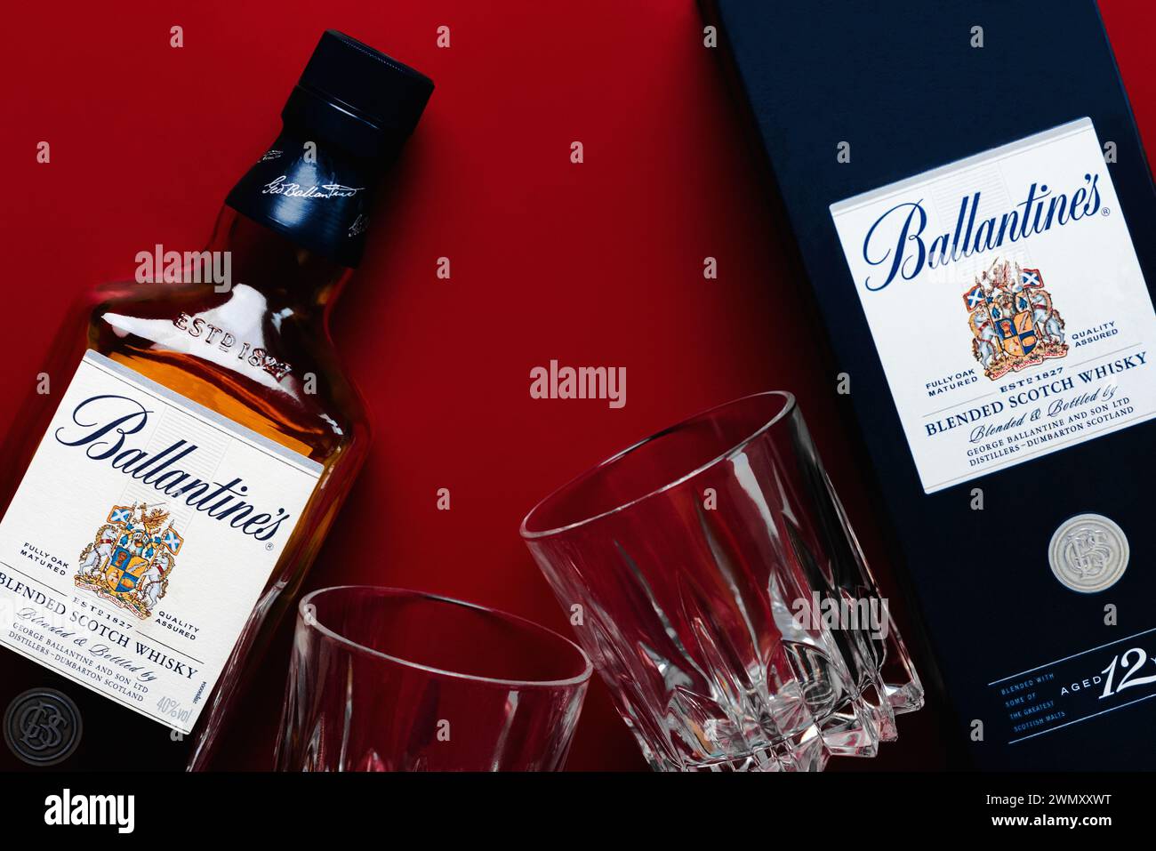 Ballantine's blended scotch whisky with two glasses of whisky over red ...
