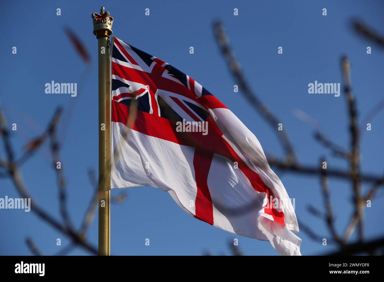 British Royal Navy White Ensign flying against a blue sky. Stock Photo