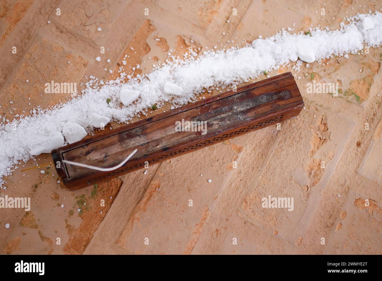 detail of wooden incense holder in the shape of a chest and grain of coarse white salt on the ceremonial floor Stock Photo