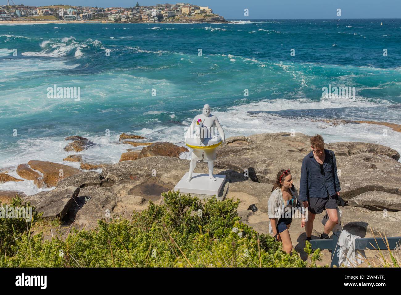 Visitors stroll past 'David' by Coady, part of the 'Sculpture by the Sea' exhibit on the coastal walk between Bondi and Tamarama beaches. Stock Photo