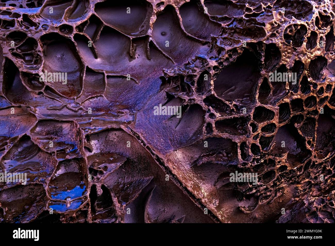 This image features close-up textures of biogenic rock formations due to biofilm bacteria found in iron-rich areas at Llumeres beach in Asturias. Stock Photo