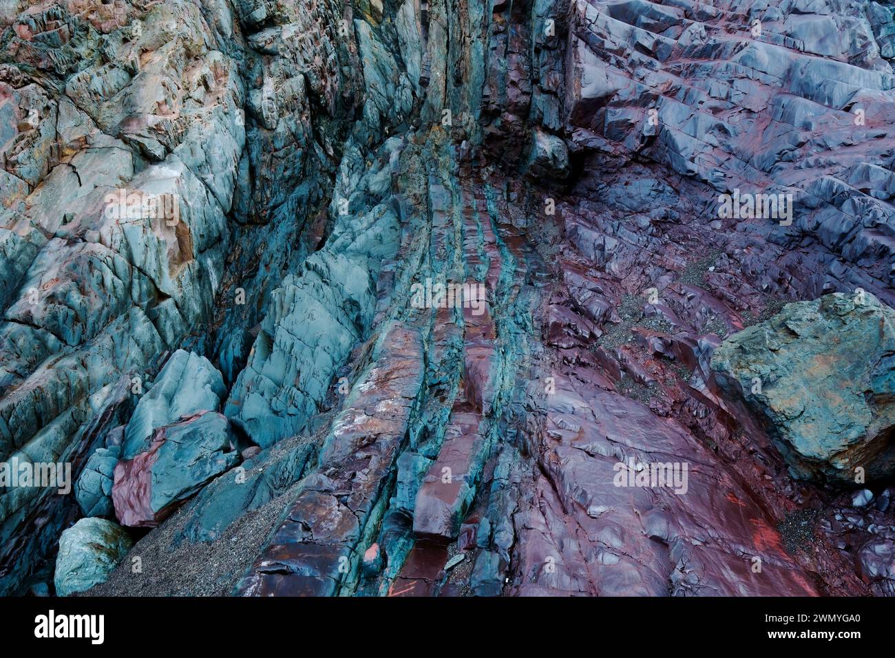 Rich biofilm bacteria proliferate on iron-rich rocks at the old mine beach of Llumeres, Asturias, showing a vivid color contrast. Stock Photo