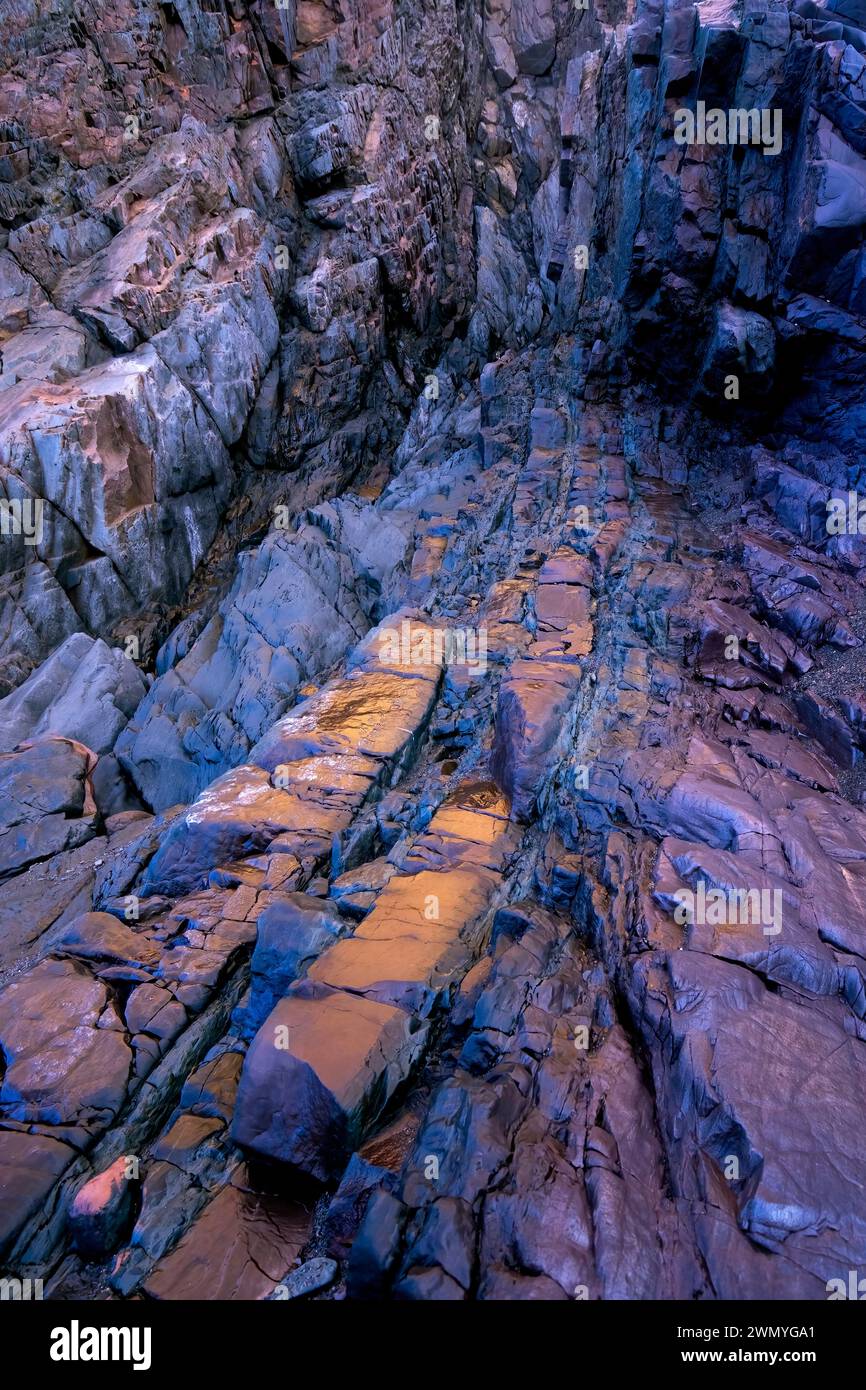 Vivid contrasts of iron-rich biofilm bacteria developing on jagged rock formations, captured at the old mine beach of Llumeres in Asturias. Stock Photo