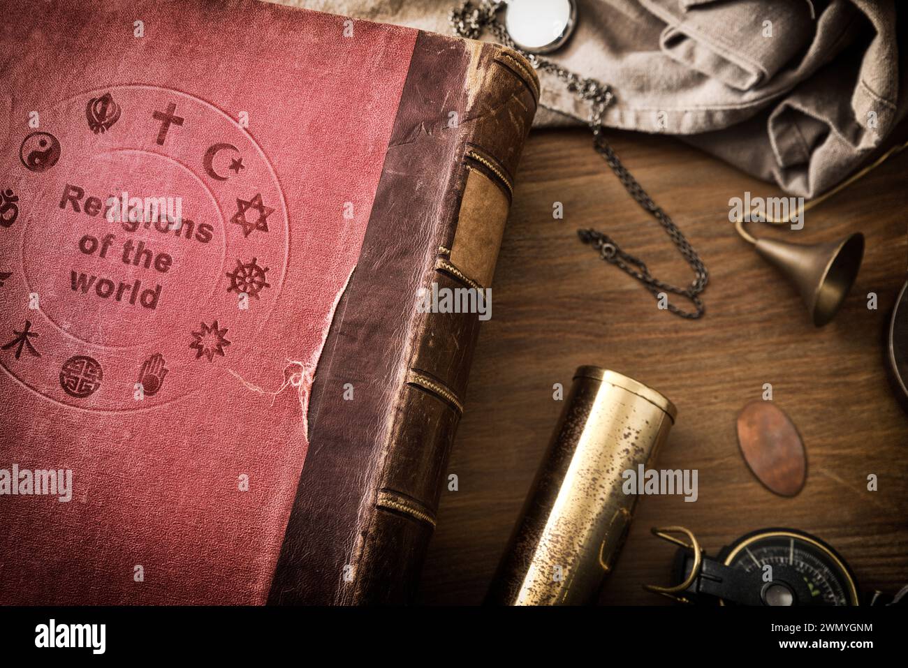 Detail of old book of the study of religions in the world wooden table with decorative objects. Top view. Stock Photo