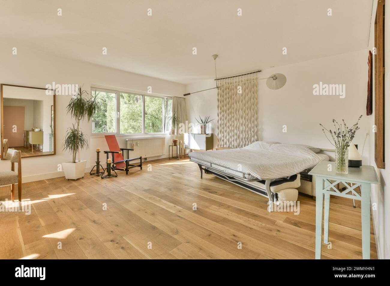 a bedroom with a bed and a table and a Stock Photo