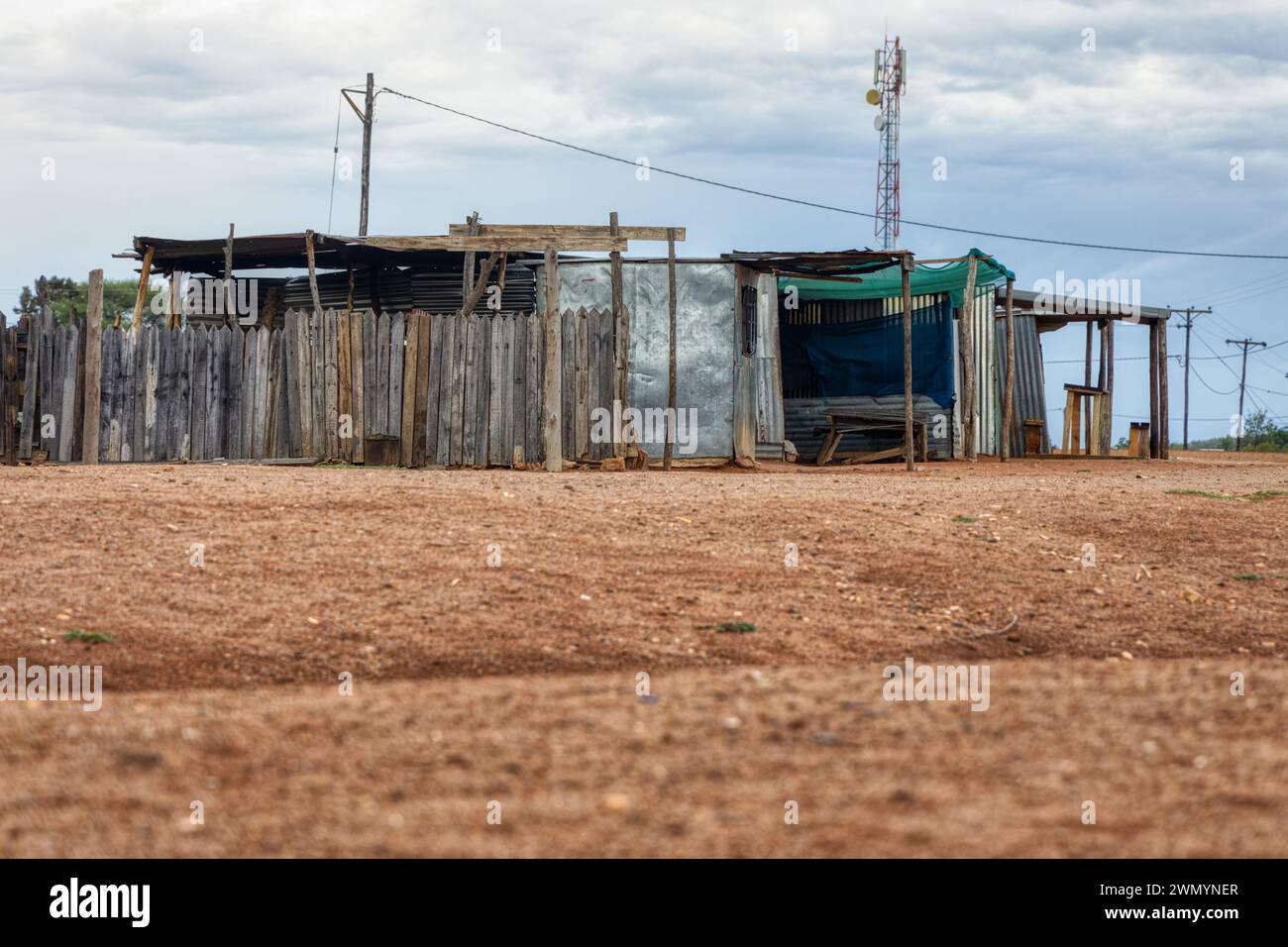township informal settlement in africa near a hill, shack made out of corrugated iron and wood, modern facilities electricity and cellular network Stock Photo