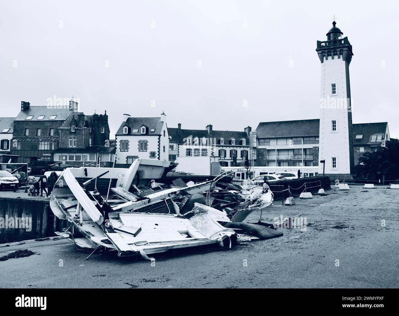 Wrecked boat in front of Roscoff Lighthouse located on the Vieux Port Roscoff, Finistere, Bretagne Breizh Brittany, France Storms 2024. Stock Photo